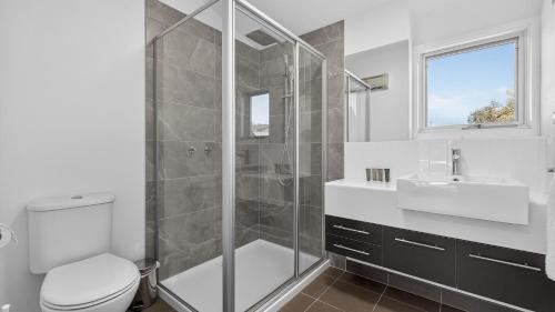 a bathroom with a shower and a toilet and a sink at Humffray 3 in Dinner Plain