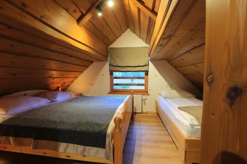 a bedroom with two beds in a wooden cabin at Vila Edelweiss Rooms&App Kranjska Gora in Kranjska Gora