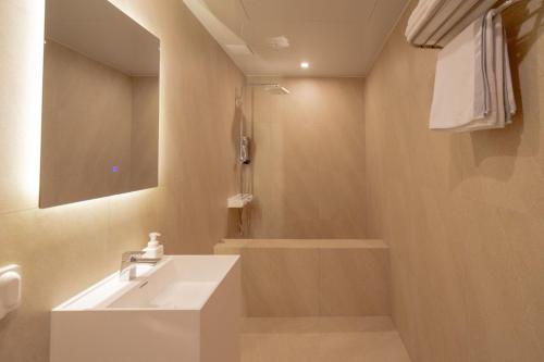 a bathroom with a sink and a bath tub at H Avenue Hotel Gwangju Cheomdan in Gwangju