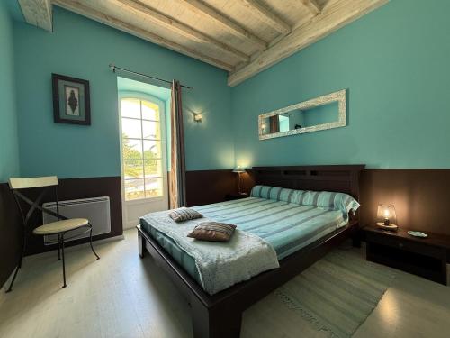 ein Schlafzimmer mit einem Bett, blauen Wänden und einem Fenster in der Unterkunft Lasquet in Mont-Disse