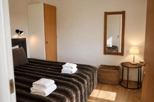 a room with a couch with a mirror and towels at KragenæsHus in Torrig