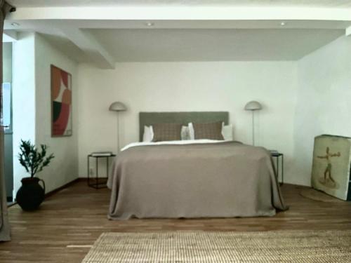 a white bedroom with a large bed with two lamps at Badklippan in Stockholm