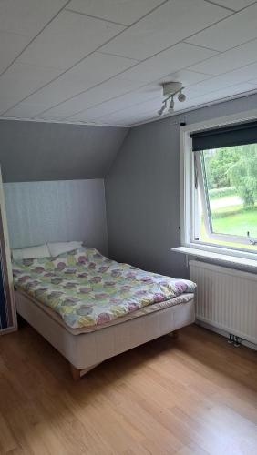 a bedroom with a bed in a room with a window at Villa Skäris in Falkenberg