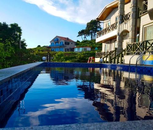 a swimming pool in front of a house at Buan Badatgaeui Chuoek Pension in Buan
