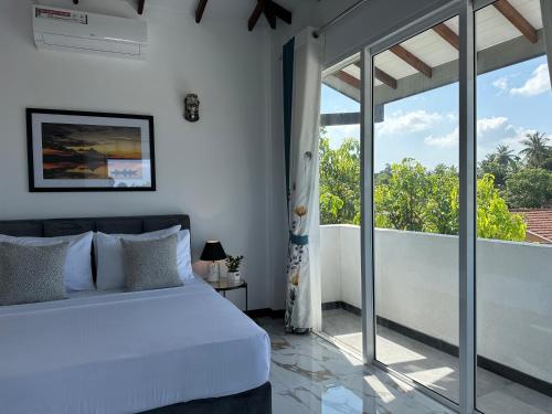 a bedroom with a bed and a large window at Kandana bliss villa in Kandana