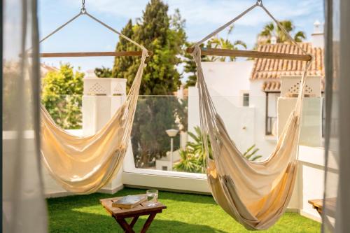 two hammocks hanging on a balcony with a table at Iberostar Selection Marbella Coral Beach in Marbella