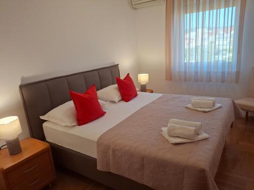a bedroom with a large bed with red pillows at Villa Fontana 2 in Sukošan