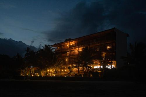 a large building with lights in front of it at night at Coast 67 Boutique Hotel in Ahangama