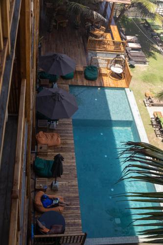 a swimming pool with people sitting under umbrellas next to it at Coast 67 Boutique Hotel in Ahangama