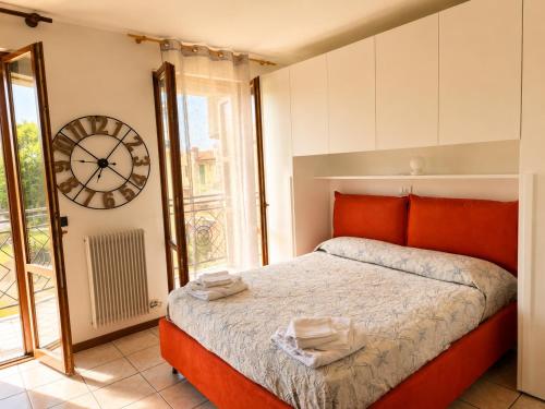 a bedroom with a bed and a clock on the wall at BeaMare - Monolocale - Massimo tre ospiti con posto spiaggia - Studio Apartment - Max 3 people with 1 private umbrella and two SunBeds at the private beach of Eraclea Mare in Eraclea Mare