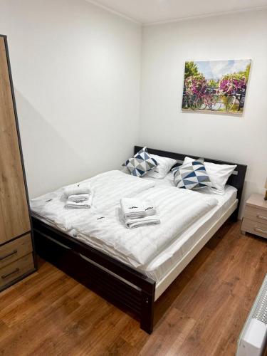 a bedroom with a bed with white sheets and pillows at Chata VeloVino in Moča