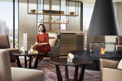 a woman sitting in a chair in a room with tables at The Ritz-Carlton, Xi'an in Xi'an