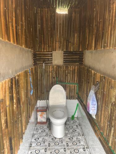 a bathroom with a toilet in a wooden wall at May Lai Homestay in Tả Van