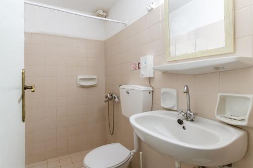 a bathroom with a sink and a toilet and a mirror at Perasma Studios 12 in Kipri