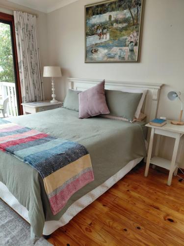 a bedroom with a large bed with a blanket at Martha's Place in Gordonʼs Bay