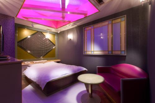 a purple bedroom with a bed and a stool at HotelG7 in Tokyo