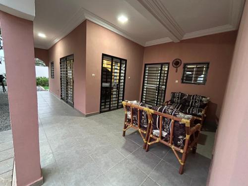 a room with brown walls and windows and chairs at Villa Djenné électricité 24h in Bamako