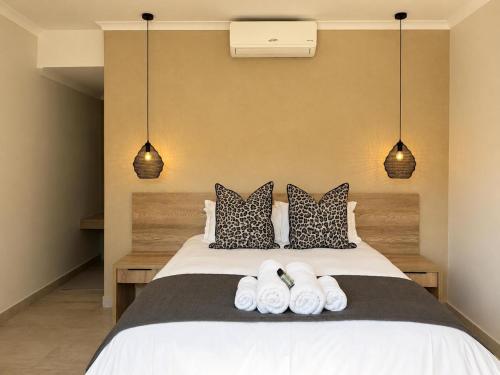a bedroom with a bed with three towels on it at Hanan Guesthouse in Thabazimbi