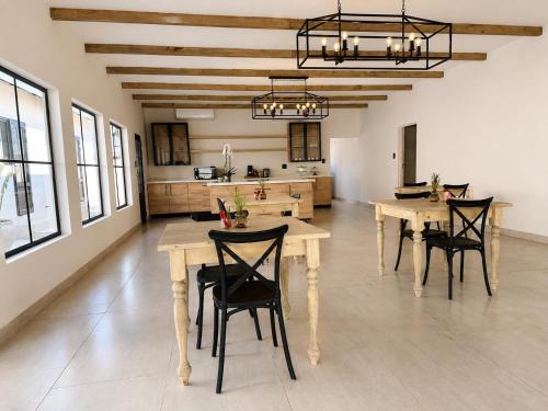a kitchen with wooden tables and chairs in a room at Hanan Guesthouse in Thabazimbi
