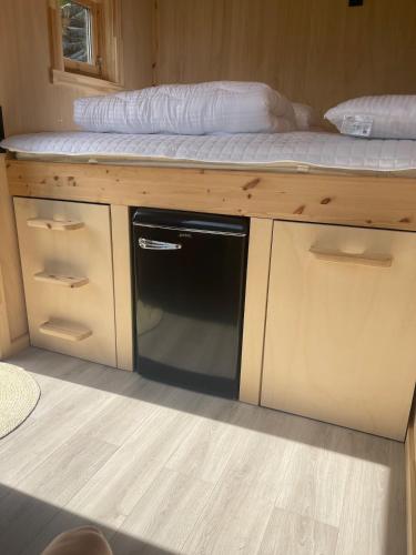 a microwave sitting on top of a wooden counter with a bed on top at Minihouse Stryn in Oppstryn