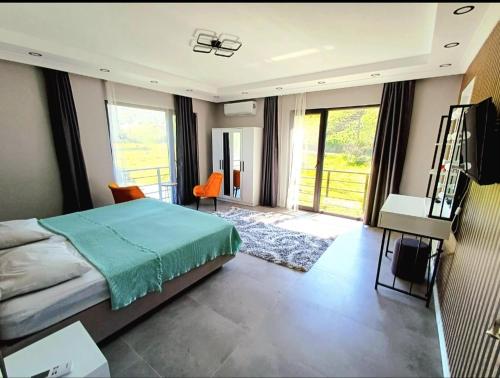 a bedroom with a bed and a desk and windows at VillaZ Villa Ardeşen in Ardeşen