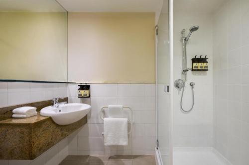 a bathroom with a sink and a shower at Rendezvous Heritage Hotel Queenstown in Queenstown