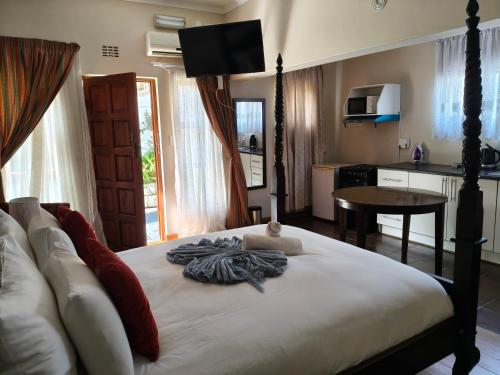 a bedroom with a bed and a kitchen with a table at The Rest Place B&B in East London