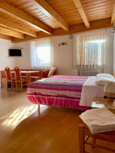 ein Schlafzimmer mit einem Bett, einem Tisch und Stühlen in der Unterkunft Alpina depandance in Castello Tesino