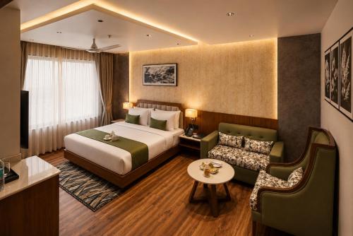 a hotel room with a bed and a couch at Four Leaf Hotel Dehradun in Dehradun