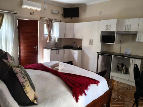 a bedroom with a bed with a red blanket on it at The Rest Place B&B in East London