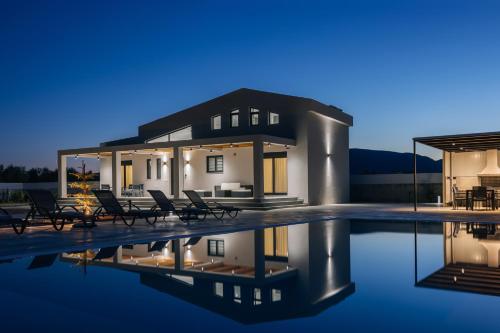a house with a swimming pool at night at Villa Samantha - Private Pool, 3 Ensuite Bedrooms & Complete Privacy near Laganas, By TK Premium Stays in Ambelókipoi
