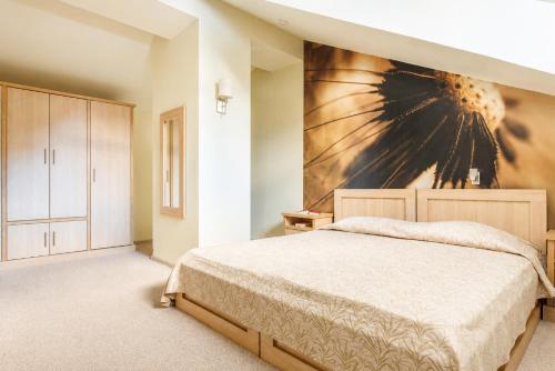 a bedroom with a bed and a painting on the wall at Effect Malina Residence Hotel in Pamporovo