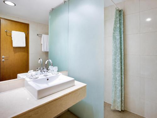 a bathroom with a sink and a shower at Effect Malina Residence Hotel in Pamporovo