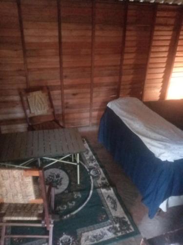 a room with a bed and a table in a cabin at Weaver's Nest Backpackers Accommodation in Nyanda