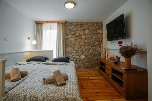 1 Schlafzimmer mit 2 Betten und einer Steinmauer in der Unterkunft Charming old stone house in Sali
