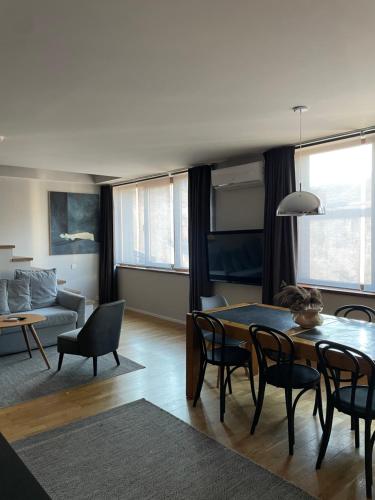 a living room with a table and chairs and a couch at Maironis 2 - Grand Apartment in the Heart of Kaunas in Kaunas
