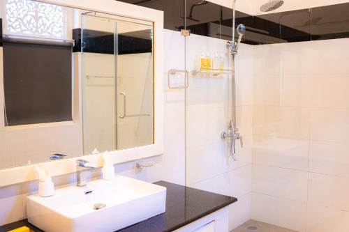 a white bathroom with a sink and a shower at Villa Labugolla in Kandy