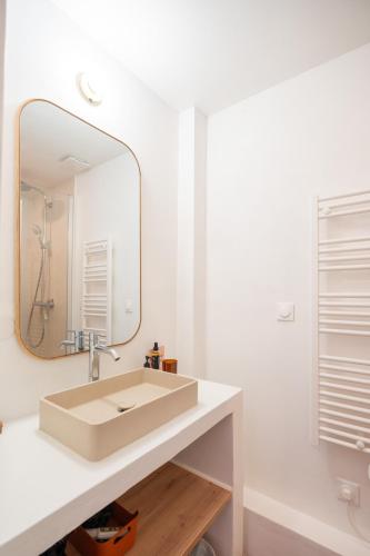 a bathroom with a sink and a mirror at Joli Cocon - Meublé de tourisme classé 2 étoiles - Terrasse - Parking in La Ciotat