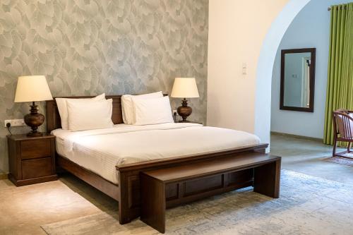 a bed in a room with two lamps and a table at Villa Labugolla in Kandy