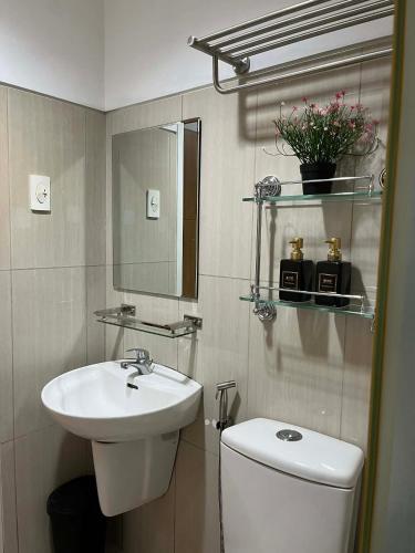 a bathroom with a sink and a toilet and a mirror at Shell Staycation in Manila