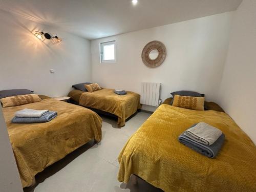 a room with two beds with yellow blankets at logement centre Bourg, parking privé in Bourg-en-Bresse
