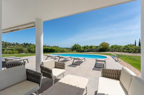 a patio with chairs and a swimming pool at Paradise Villa Cabanita Loulé in Loulé