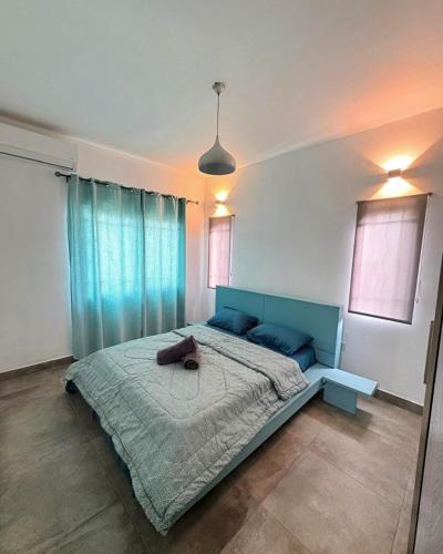 a bedroom with a large bed with a blue headboard at Villa Orchidees-Albion in Albion