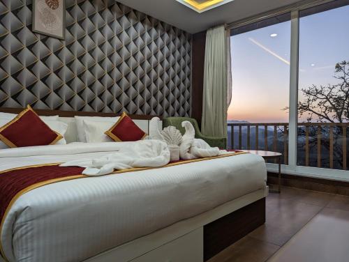 a bedroom with a bed with a large window at OXYRICH in Madikeri
