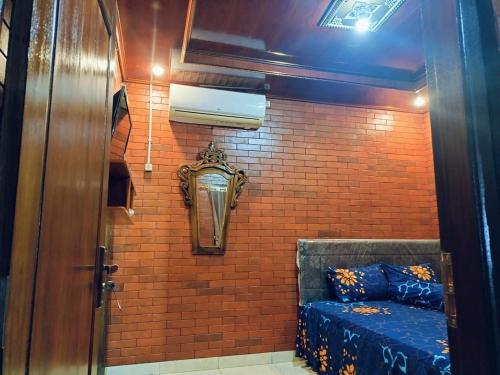 a room with a brick wall with a bed in it at Limasan Mbah Darmo in Tepus