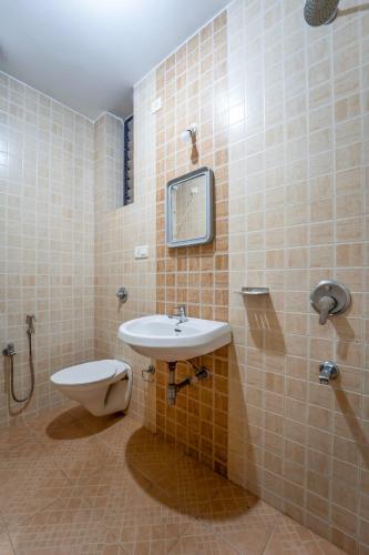 a bathroom with a sink and a toilet at Old Goa Residency in Old Goa