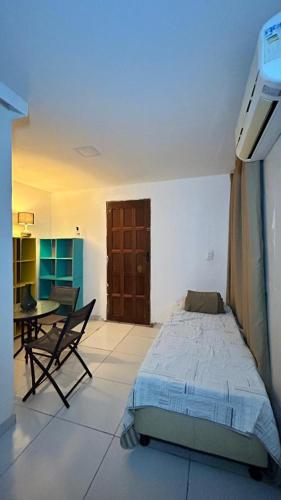 a bedroom with a bed and a table in it at Fenomenall Kitnet in Campina Grande
