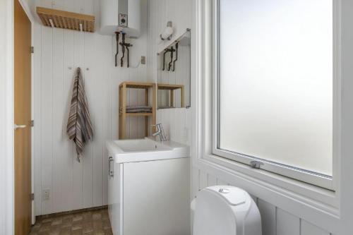 a white bathroom with a sink and a toilet at Simple Summer Living In Magical Setting in Nykøbing Sjælland