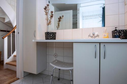 a small white bathroom with a sink and a stool at Cozy Central Located Townhouse In Nakskov in Nakskov