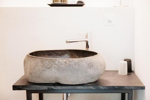 a bathroom with a concrete sink on a counter at Casa Martinelli, Boutique-Hotel in Maggia